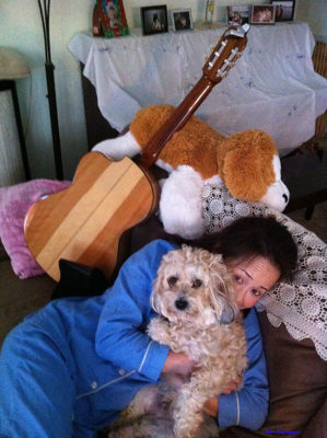 Photo of Joanna hugging me on the couch with Johnnie's guitar in the background and a large stuffed doggy.